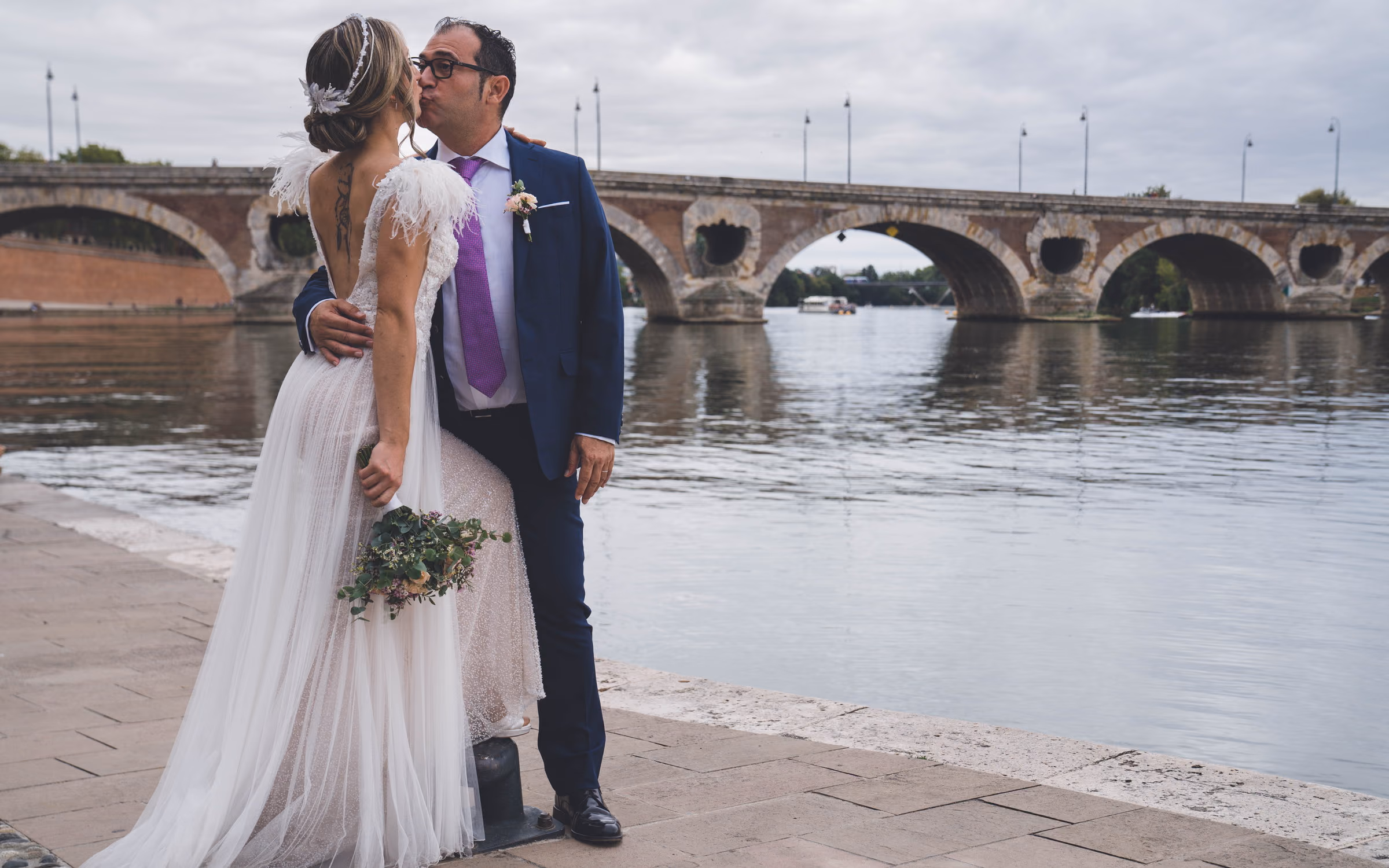 The couple at the water’s edge, a stone bridge behind them