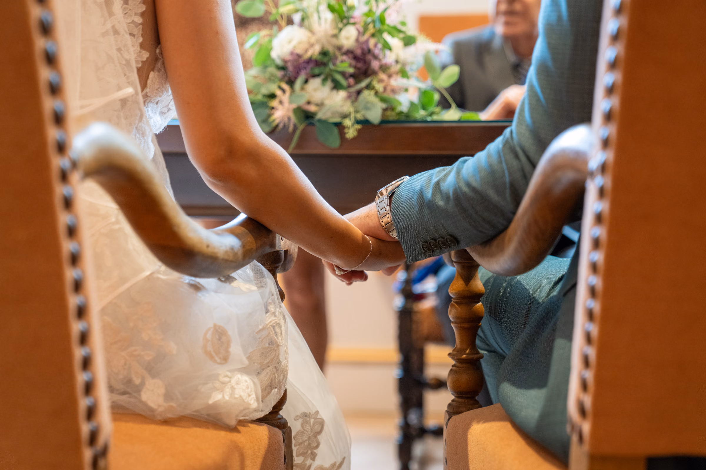 The couple’s hands joined during the ceremony, on a wooden armrest