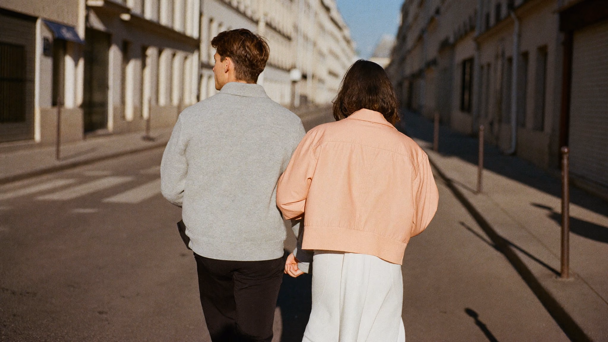 A couple walking a Paris street in early morning light