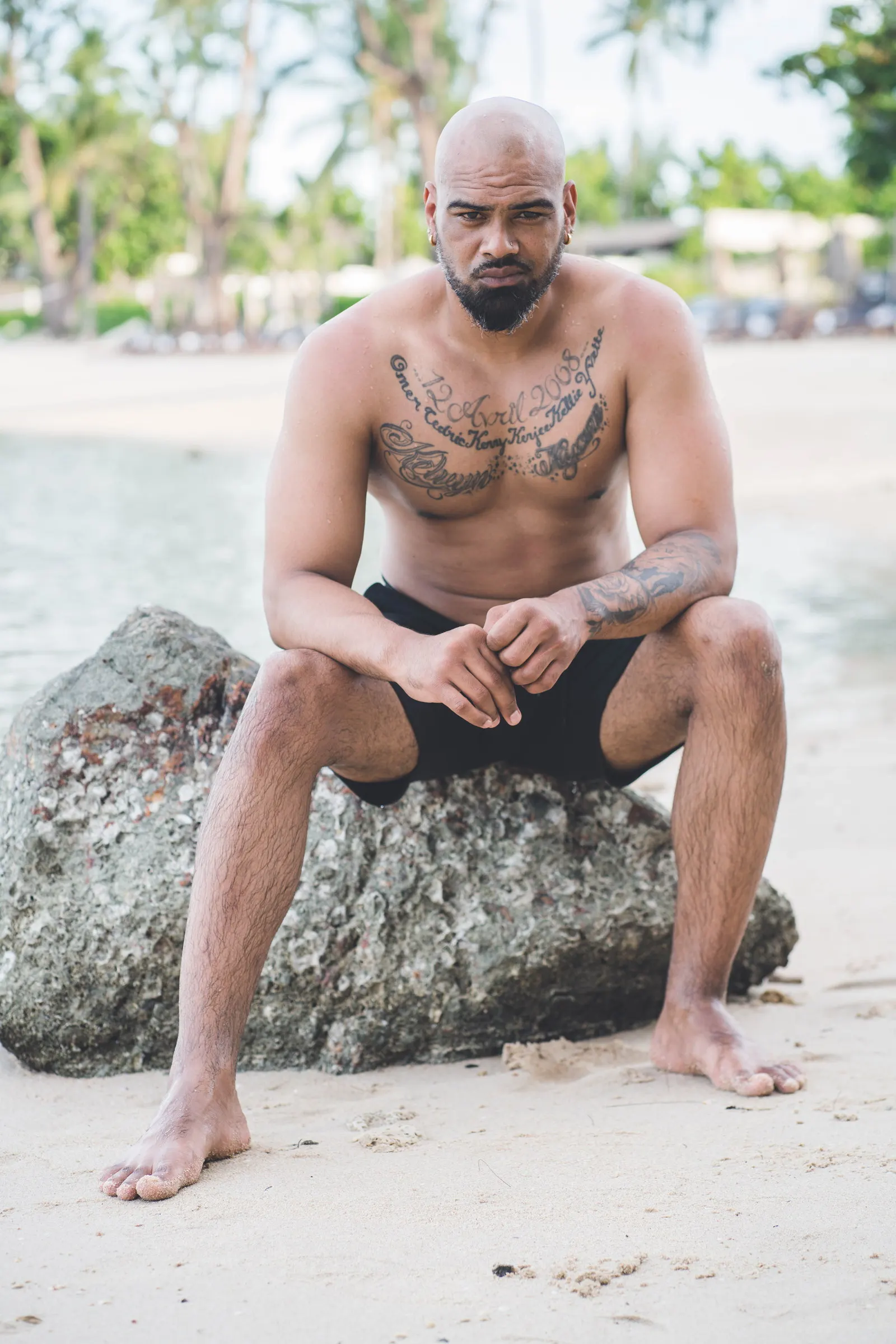 Un homme assis sur un rocher au bord de l’eau