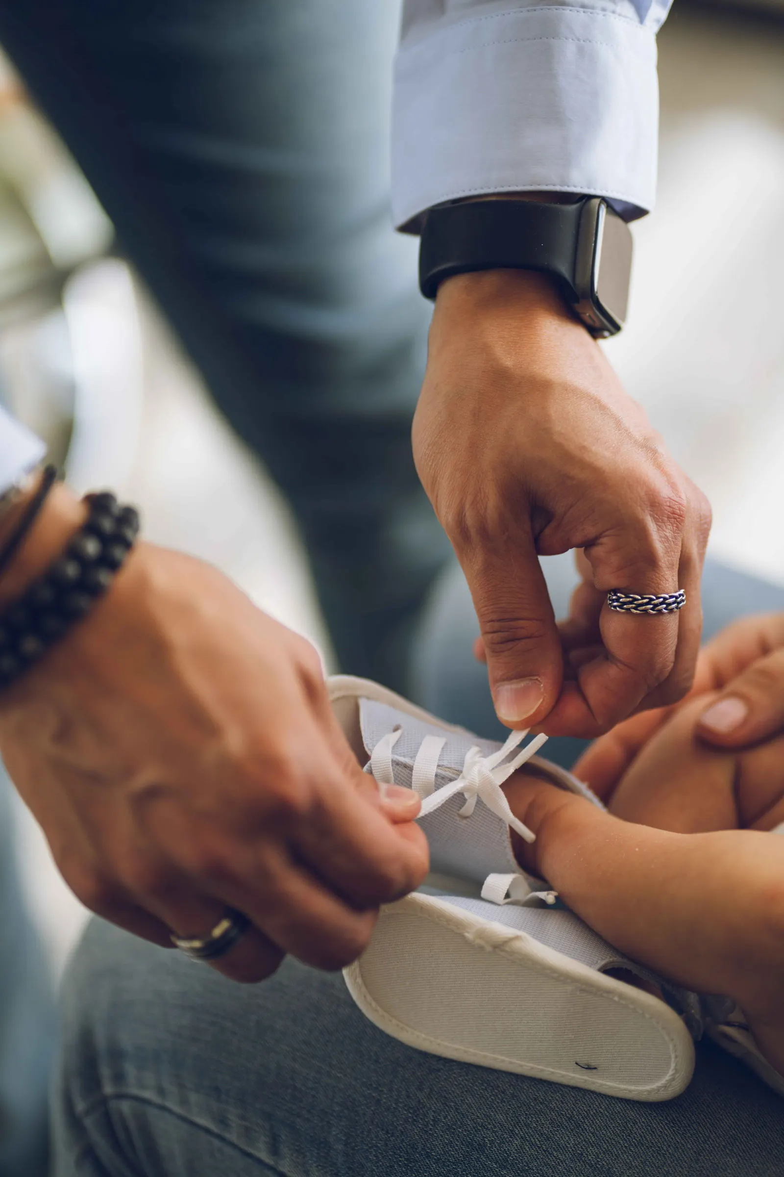 Des mains d’adultes attachant un bracelet de naissance