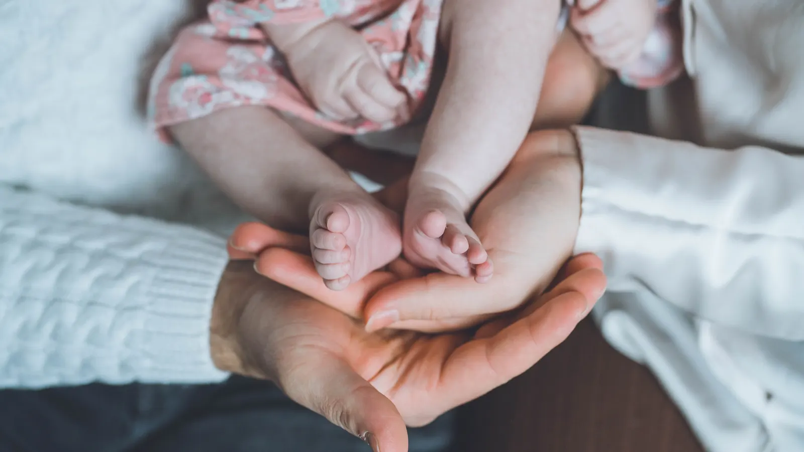 Les pieds d’un nouveau-né tenus dans les mains de ses parents