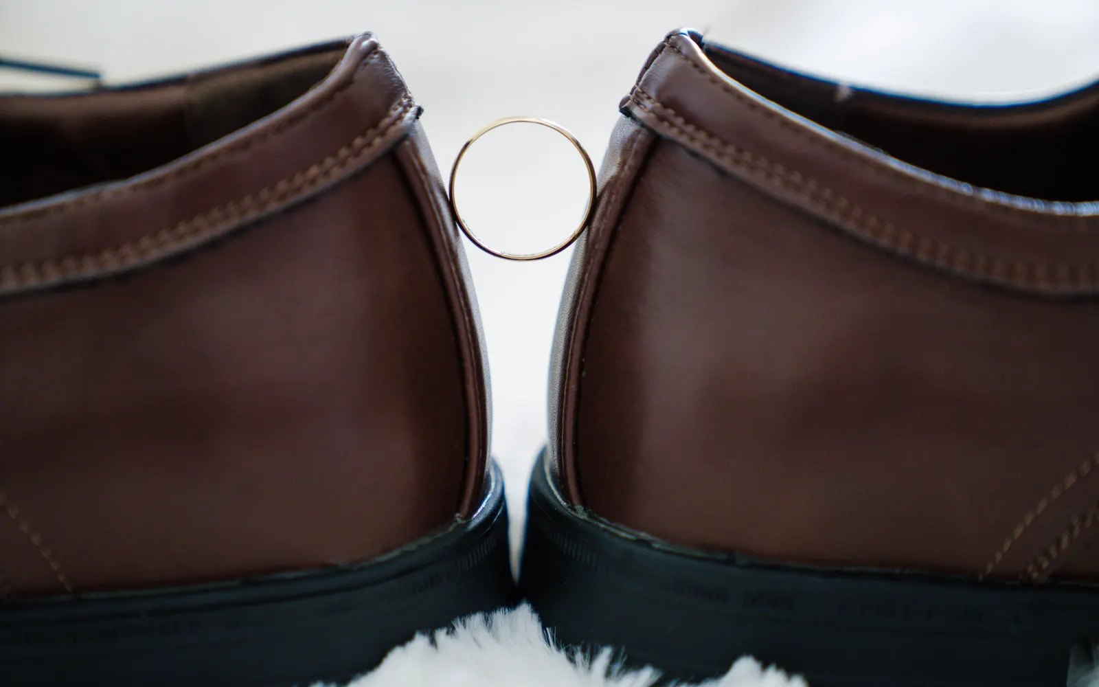 Une paire de chaussures en cuir et une alliance, en gros plan