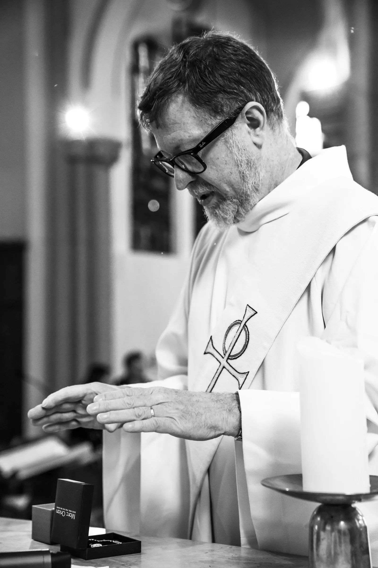 En noir et blanc, un prêtre à l’autel pendant un baptême