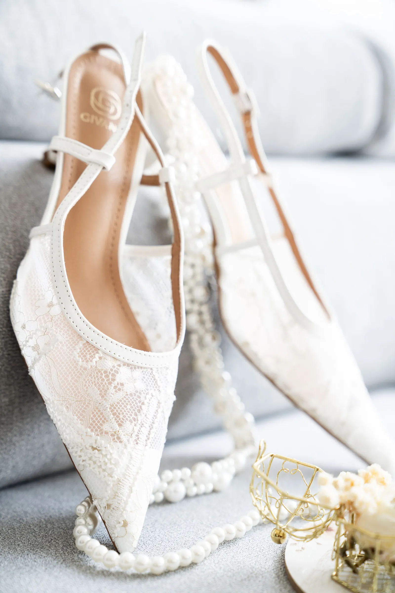 Une paire d’escarpins en dentelle et un rang de perles