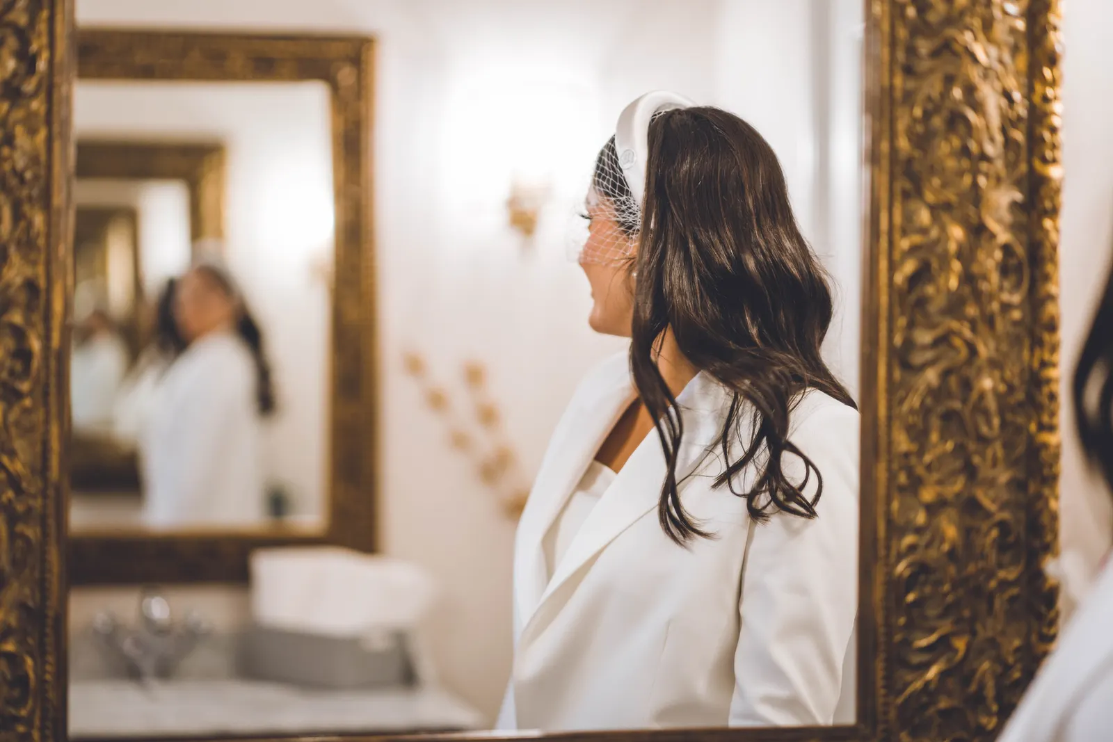 La mariée de profil devant un miroir, un serre-tête dans les cheveux